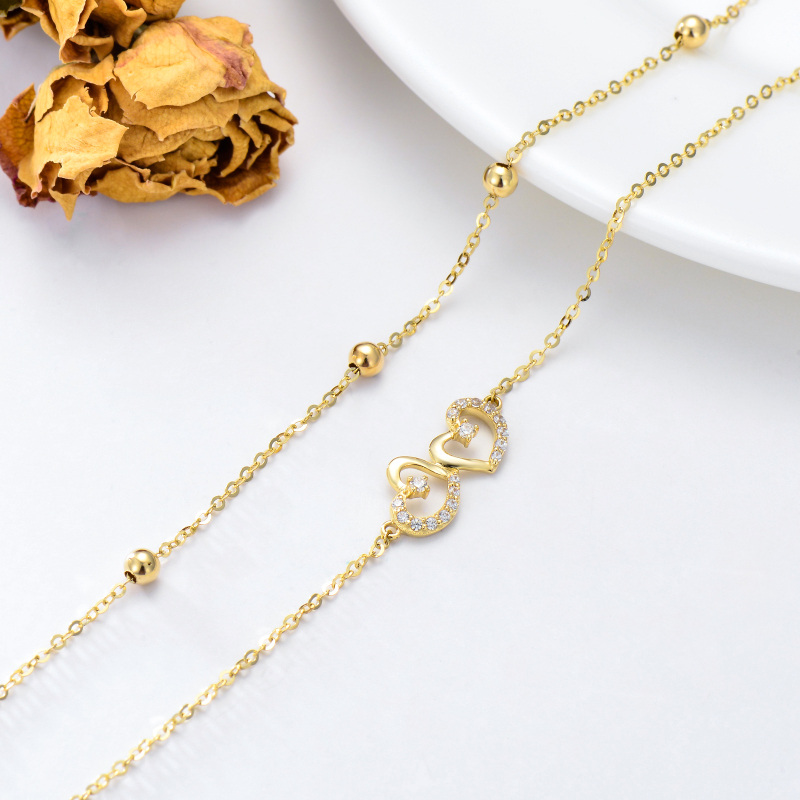 Tornozeleira com pendente de coração e zircónia cúbica de corte redondo em ouro branco de 10 quilates com várias camadas de pendentes de coração.-4