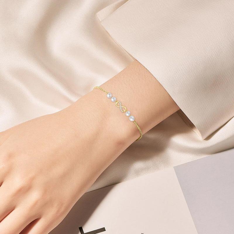 Pulsera con dije de símbolo infinito de perla y diamantes en oro de 18 quilates-2
