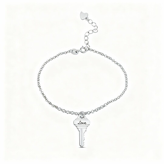 Pulseira com pendente de chave em ouro branco 10K e palavra gravada.