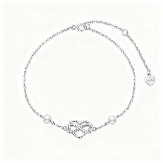 Pulsera con dije de corazón y símbolo de infinito en oro blanco de 10 quilates con circonitas cúbicas y perlas