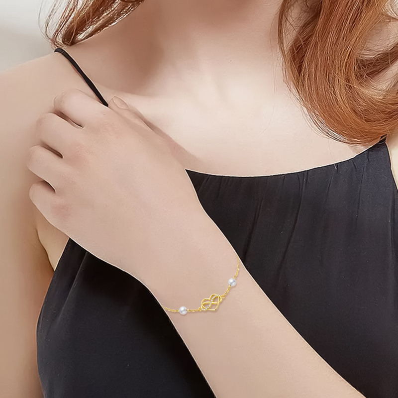 Pulseira de senhora em ouro 14K com pérola, pendente de coração e símbolo do infinito em zircónia cúbica.-2