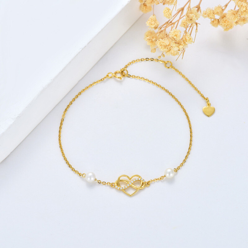 Pulseira de senhora em ouro 14K com pérola, pendente de coração e símbolo do infinito em zircónia cúbica.-3