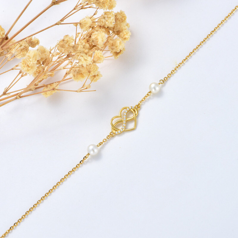 Pulseira de senhora em ouro 14K com pérola, pendente de coração e símbolo do infinito em zircónia cúbica.-4